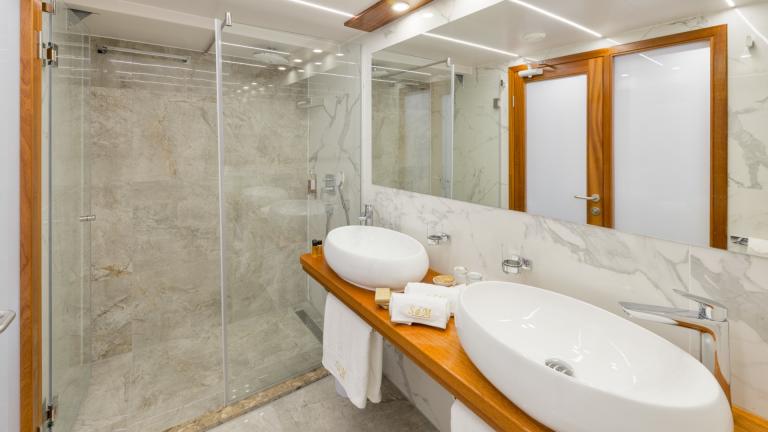 Ein helles Badezimmer mit ebenerdiger XXL Regendusche in der Master Kabine der Son de Mar.